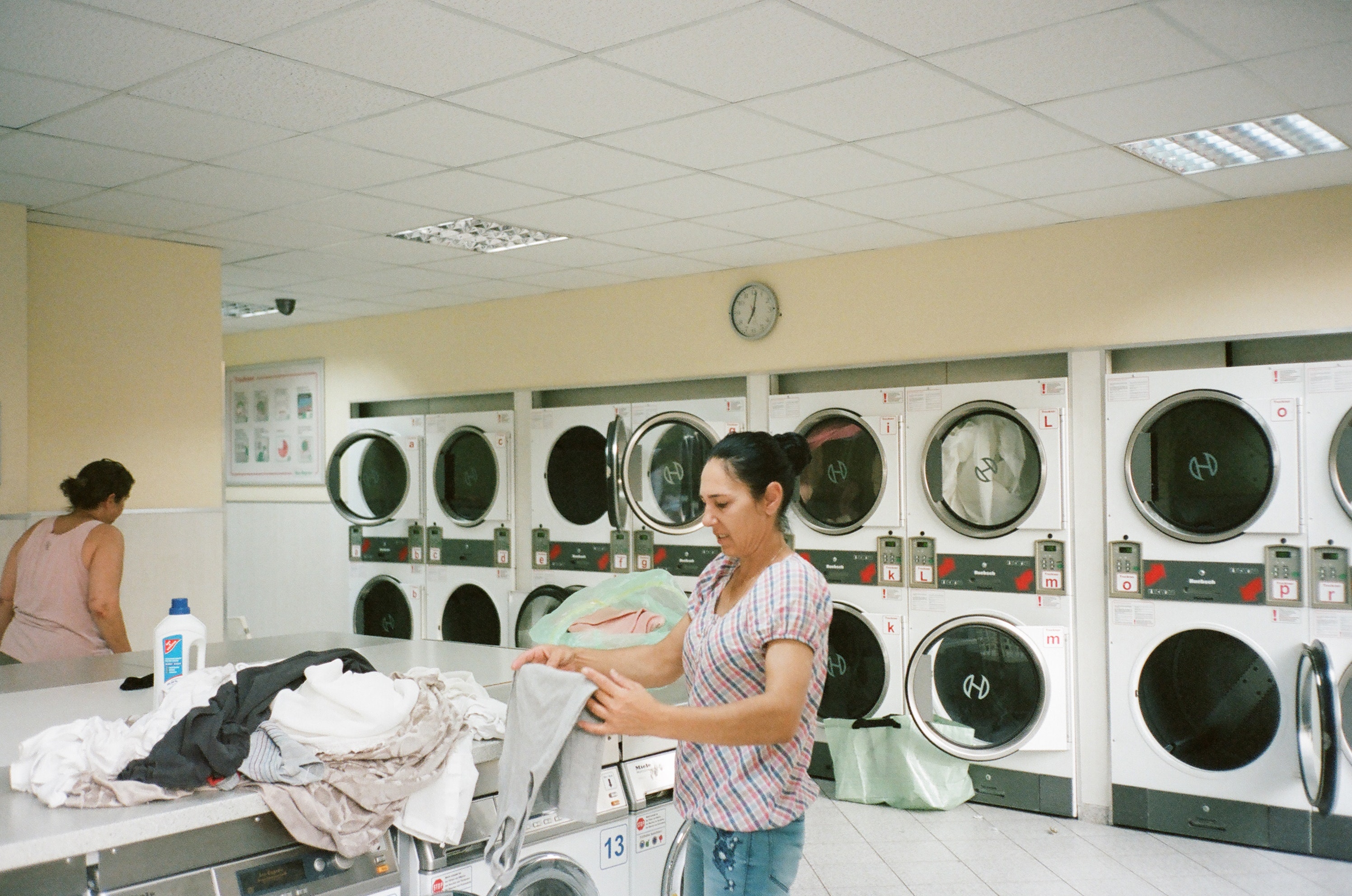 photo-of-woman-standing-inside-the-laundromat-2927523
